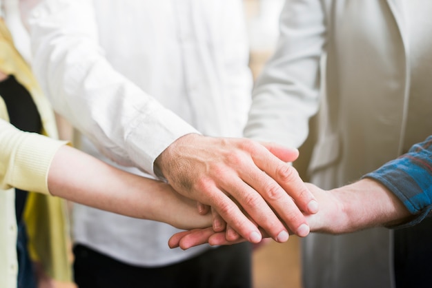 Businesspeople stacking their hands for showing unity