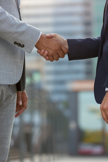 Businesspeople standing in city street and shaking hands