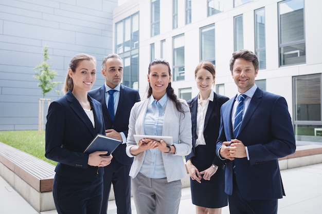 Free photo businesspeople standing outside office building