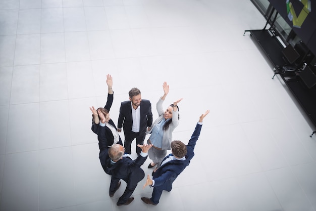 Businesspeople standing with hands raised