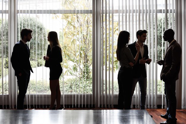 Businesspeople talking close to the window at the office