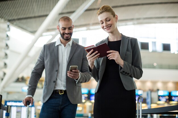 Businesspeople waiting in queue at a check-in counter with luggage