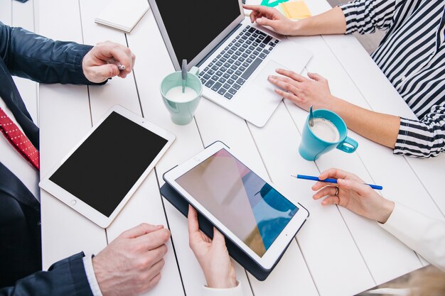 businesspeople with devices at table