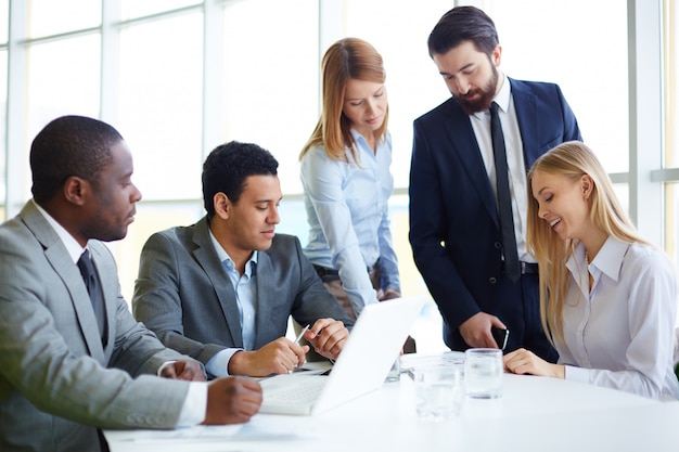 Businesspeople working on laptop in office