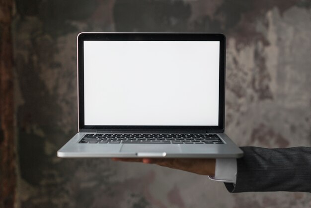 Businessperson holding laptop with blank white screen