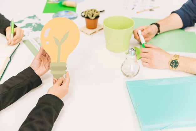 Foto gratuita la mano della persona di affari che tiene l'icona della lampadina