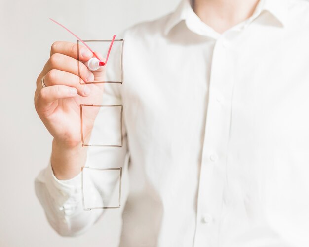 Businessperson's hand marking on check box with red marker over screen