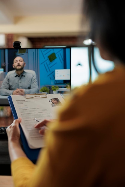 Businesswoman analyzing candidate cv discussing hiring cv with remote man during online videocall meeting. Businesspeople working at company strategy discussing partnership in startup office