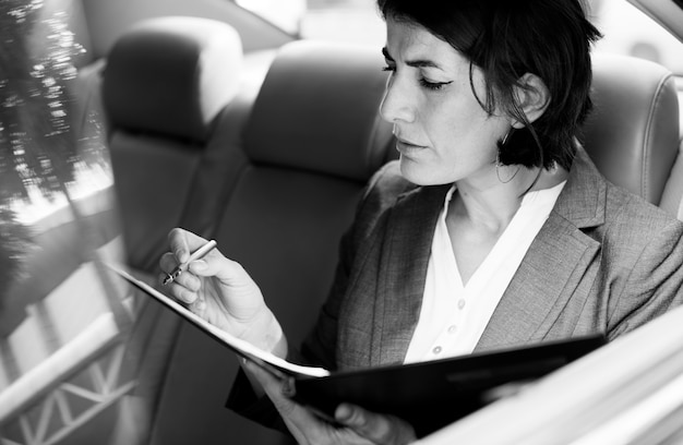 Free photo businesswoman busy working car inside