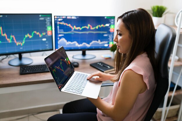 Businesswoman buying stocks online. Hispanic young woman working from home on her trading business on a laptop