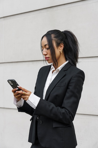 Free photo businesswoman checking smartphone