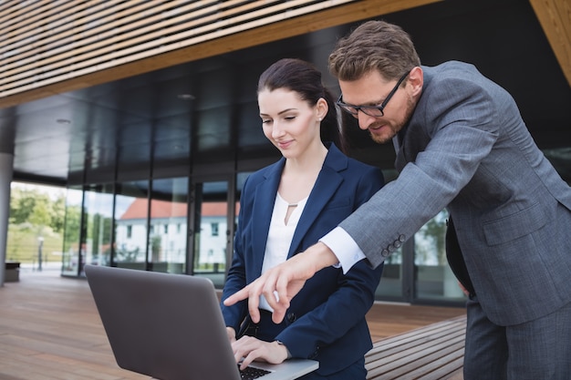 Free photo businesswoman and colleague using laptop