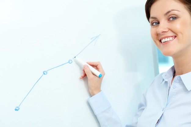 Free photo businesswoman drawing on the blackboard