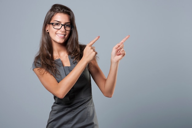 Businesswoman in dress showing the direction