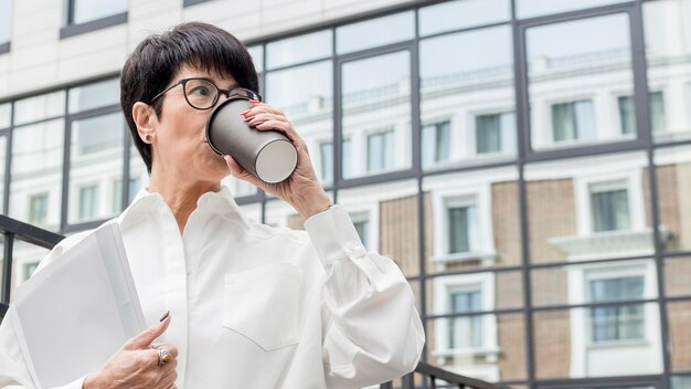 Businesswoman drinking coffee low view