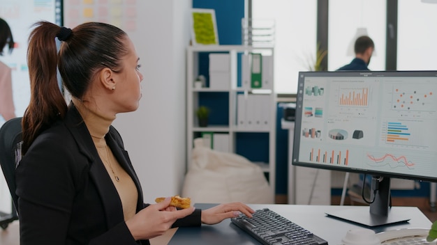 Businesswoman having delivery food order on desk during takeout lunchtime working in business company office