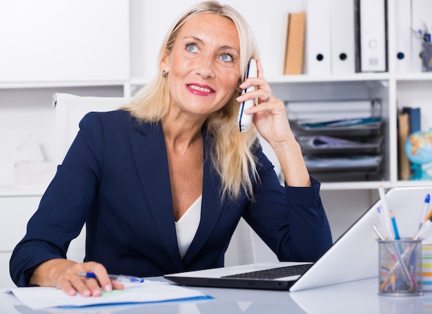 Businesswoman having phone conversation in office