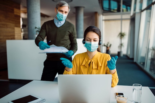 Foto gratuita imprenditrice e il suo collega che hanno una teleconferenza sul laptop dall'ufficio