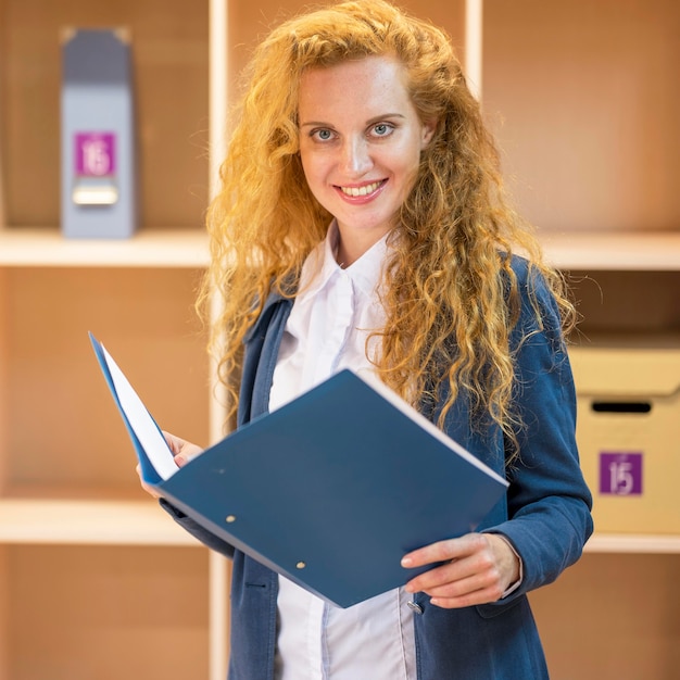 Free photo businesswoman holding a blue document folder