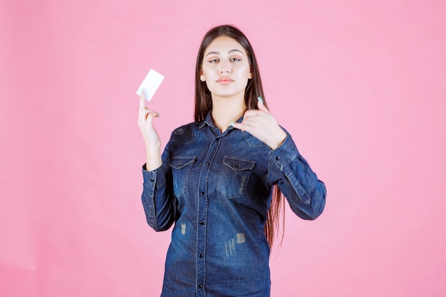 Businesswoman holding a business card and asking to call