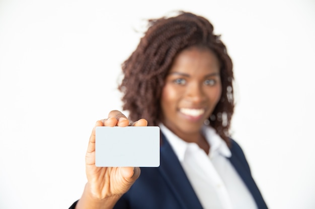 Businesswoman holding card and smiling at camera
