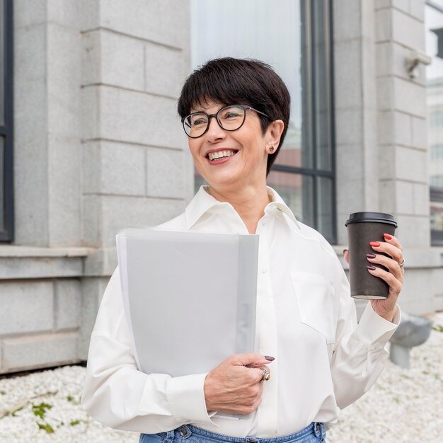 Businesswoman holding coffee and smiles