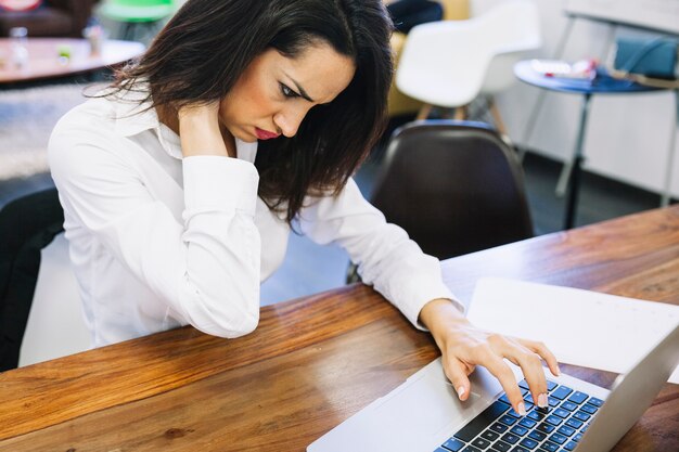 Businesswoman holding her neck