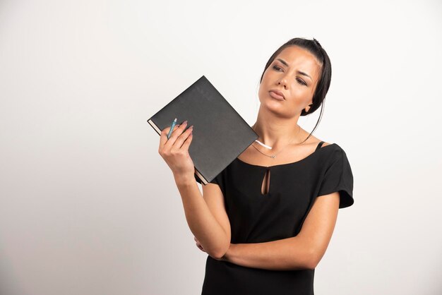 Businesswoman holding notebook while looking aside.