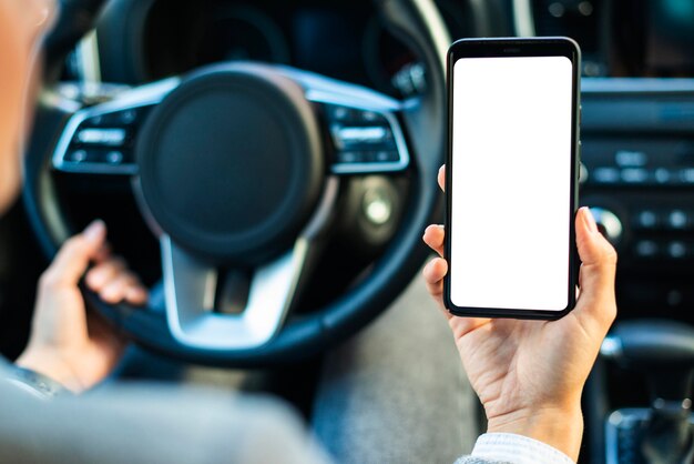 Businesswoman holding smartphone in the car