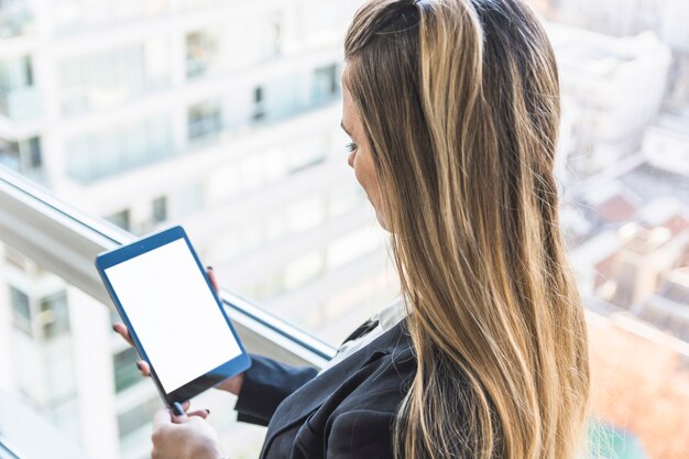 Businesswoman looking at digital tablet with white display screen