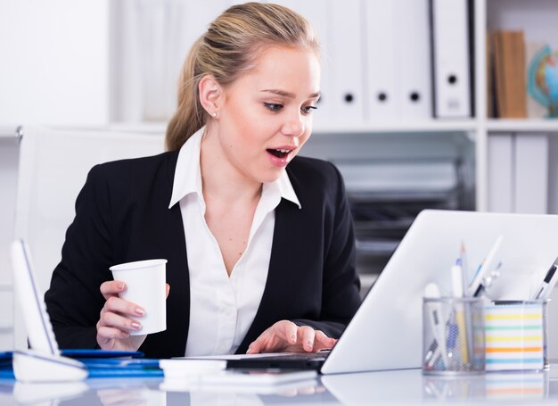 Businesswoman looking at monitor in surprise