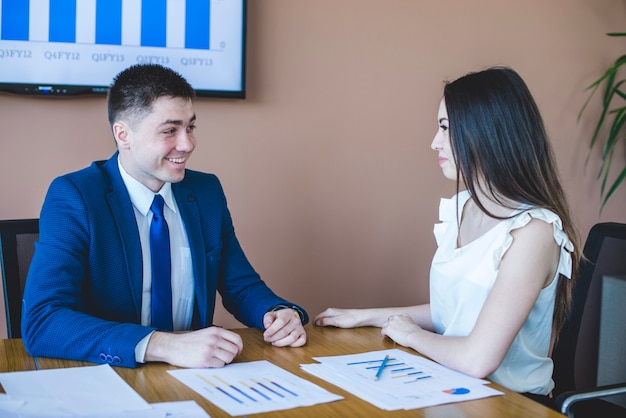 Free photo businesswoman and man sitting at table