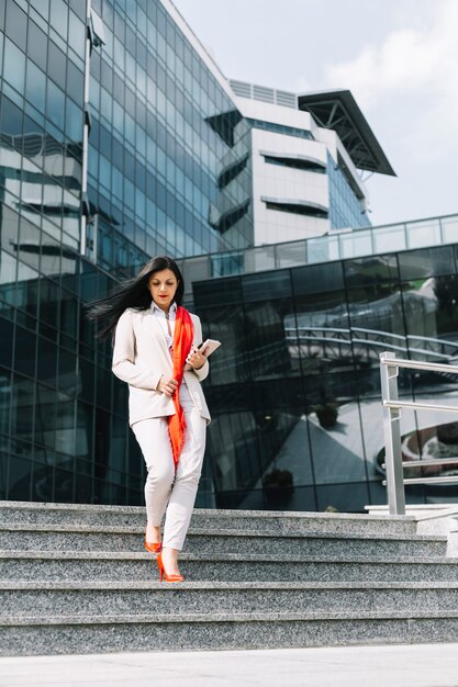 Businesswoman moving down staircase in front of building