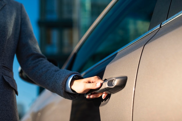 Free photo businesswoman opening her car door