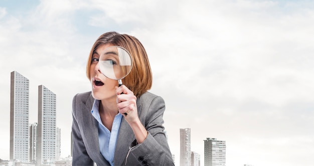 Businesswoman playing with a magnifying glass