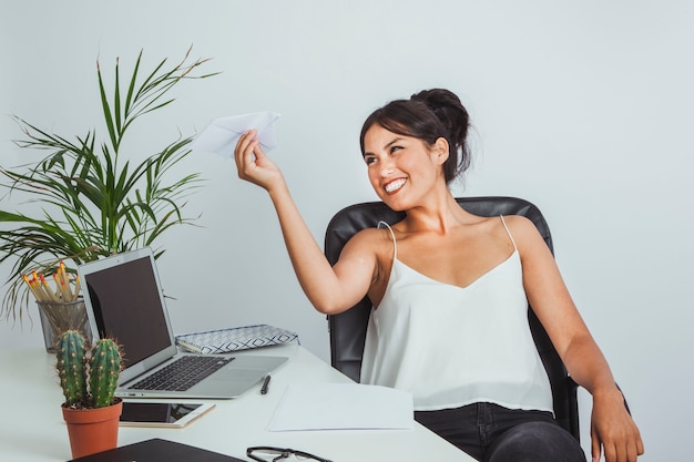 Businesswoman playing with a paper plane