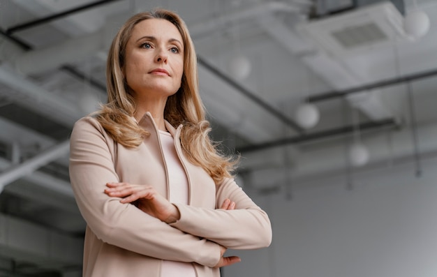 Free photo businesswoman posing with her arms crossed with copy space