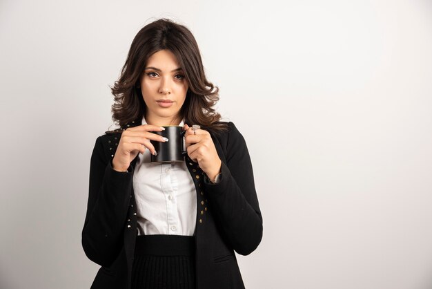 Businesswoman posing with tea on white