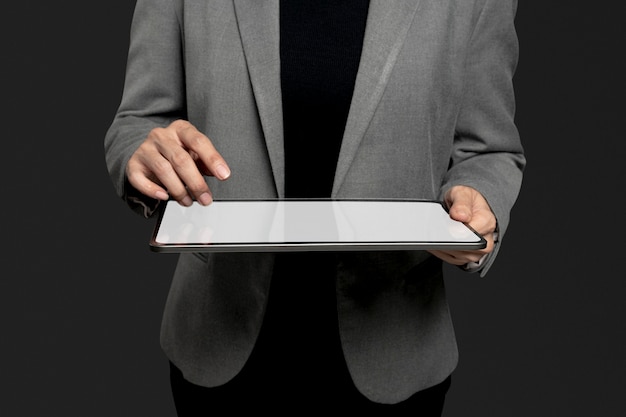 Деловая женщина, представляющая невидимую голограмму, проецирующуюся с передовых технологий планшета