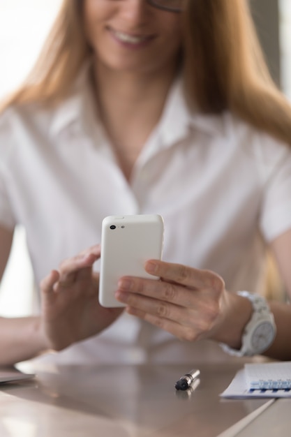 Businesswoman reading message on modern cellphone