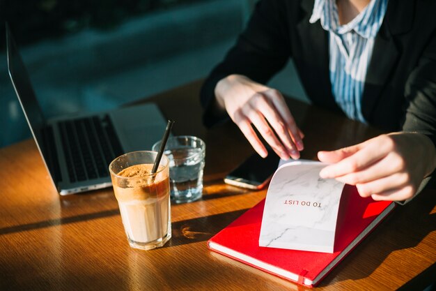 Businesswoman's hand checking to do list in restaurant