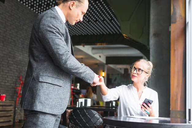 カフェで彼女のパートナーと握手をするビジネスマン