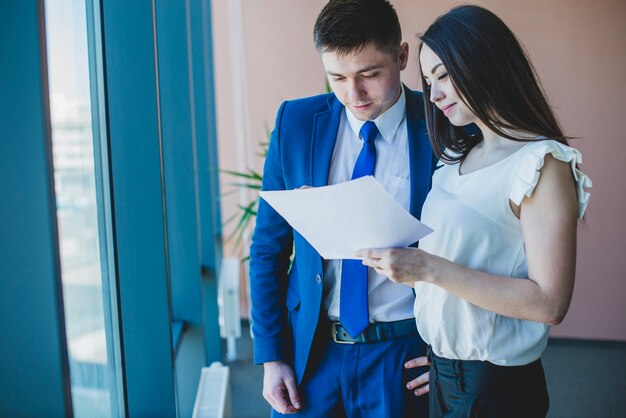 businesswoman showing document to businessman
