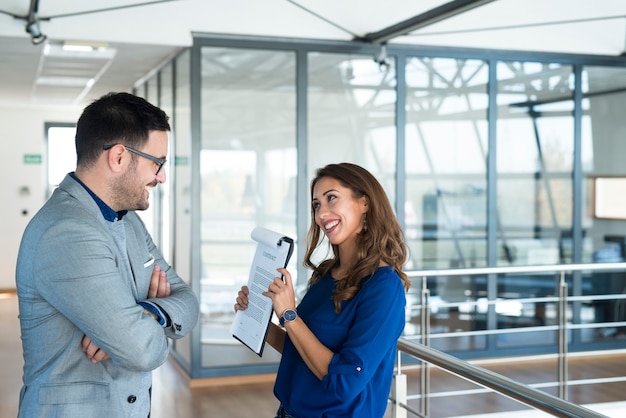 Businesswoman showing documents to the marketing manager in company's office