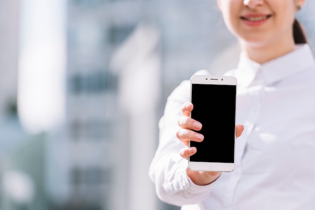 Businesswoman showing smartphone outdoors