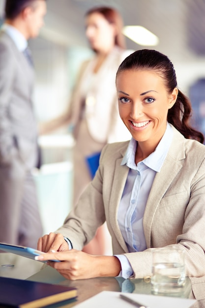 Businesswoman sitting at desk and looking business news