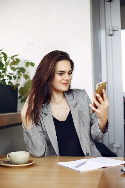 Businesswoman sitting at the table in a cafe and working 