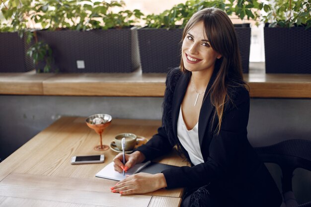 Businesswoman sitting at the table in a cafe and working 