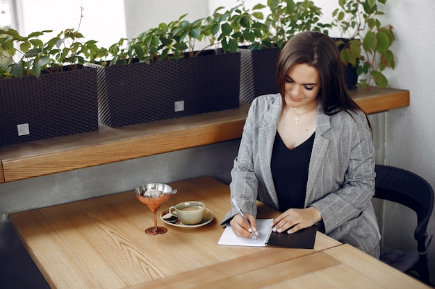 Free photo businesswoman sitting at the table in a cafe and working