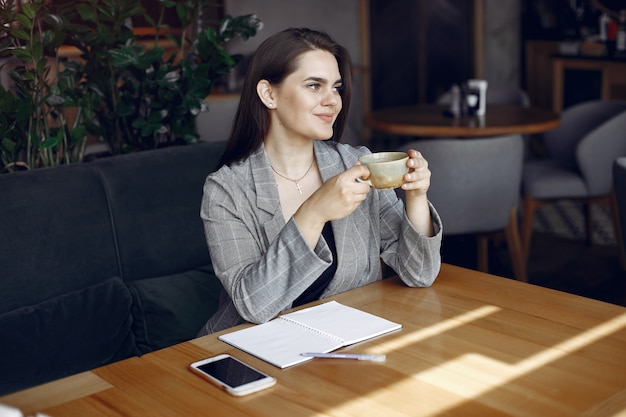 Businesswoman sitting at the table in a cafe and working 